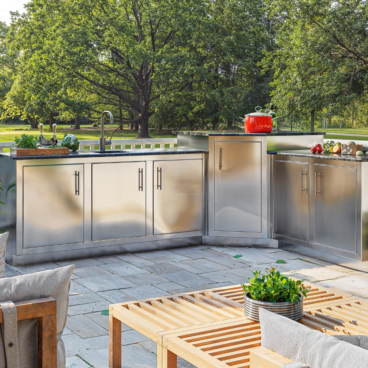 Rocket Outdoors stainless steel outdoor kitchen with storage cabinets, sink, countertop prep space, and toe kick on a backyard patio.