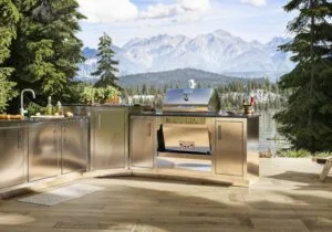 Stainless steel Silver Rocket outdoor kitchen with built-in grill, sink, and prep stations overlooking a mountain lake.