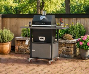 Sonic Rocket small cabinet charcoal smoker on a brick patio with rubs, sauces, and grilled steak on the side shelf in front of a wood fence.
